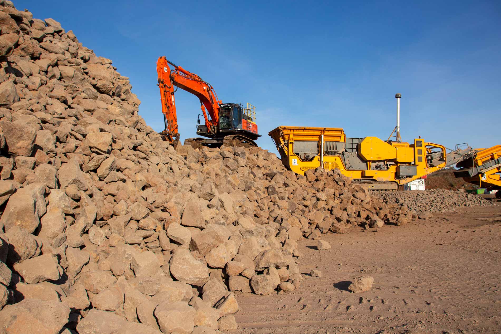 Image of crushed rock and machinery in background